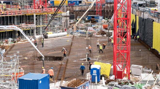 A bustling construction site in Hamburg with workers and equipment actively engaged in building tasks.